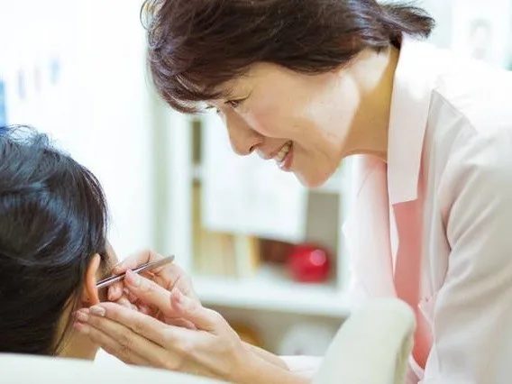 耳つぼのケアをする代表の加藤